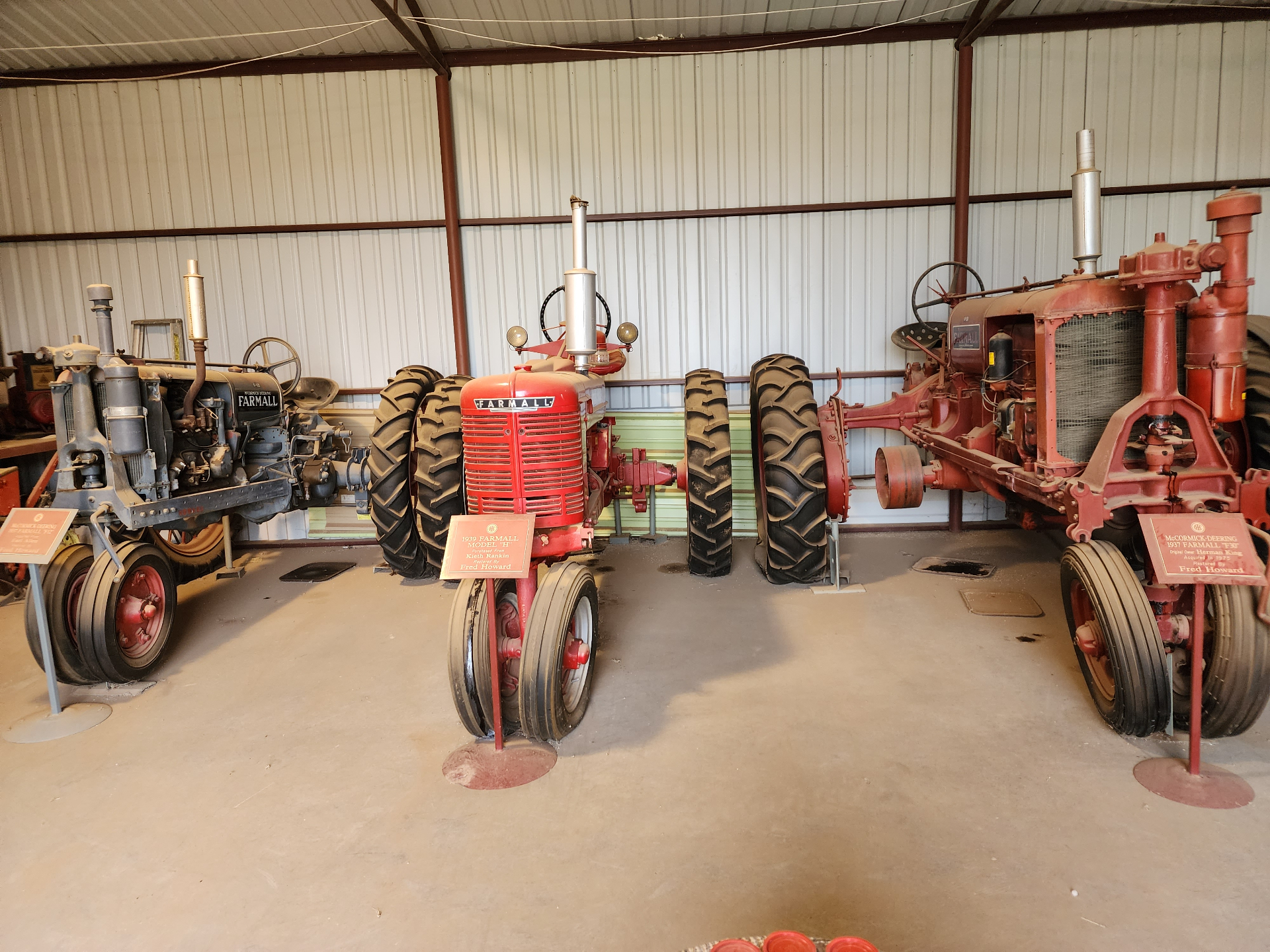 Row of restored vintage Farmall and McCormick-Deering tractors on display inside the museum exhibit hall